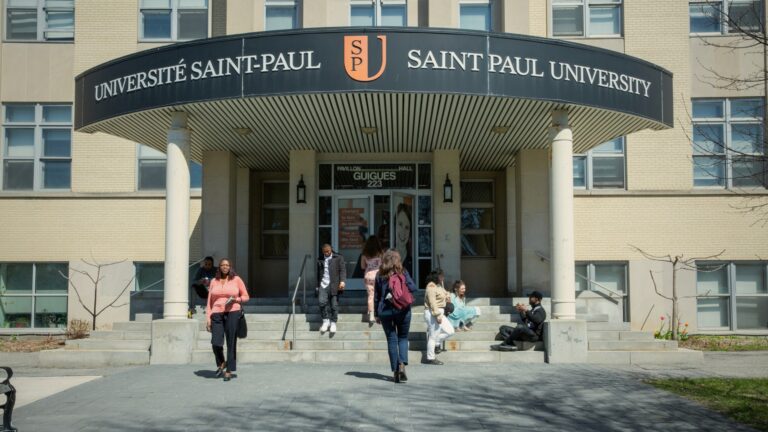 Étudiantes et étudiants devant l’entrée du pavillon Guigues de l’Université Saint-Paul, au 223, rue Main