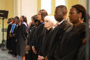 Graduates in academic gowns stand together during the convocation ceremony.