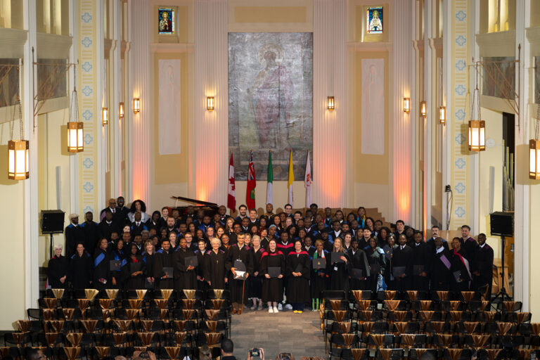 Graduates and faculty of the morning ceremony gather for a group photo in the De Mazenod Chapel.