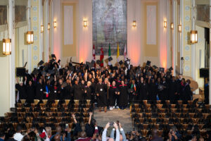 Morning ceremony graduates toss their caps in celebration in the De Mazenod Chapel.
