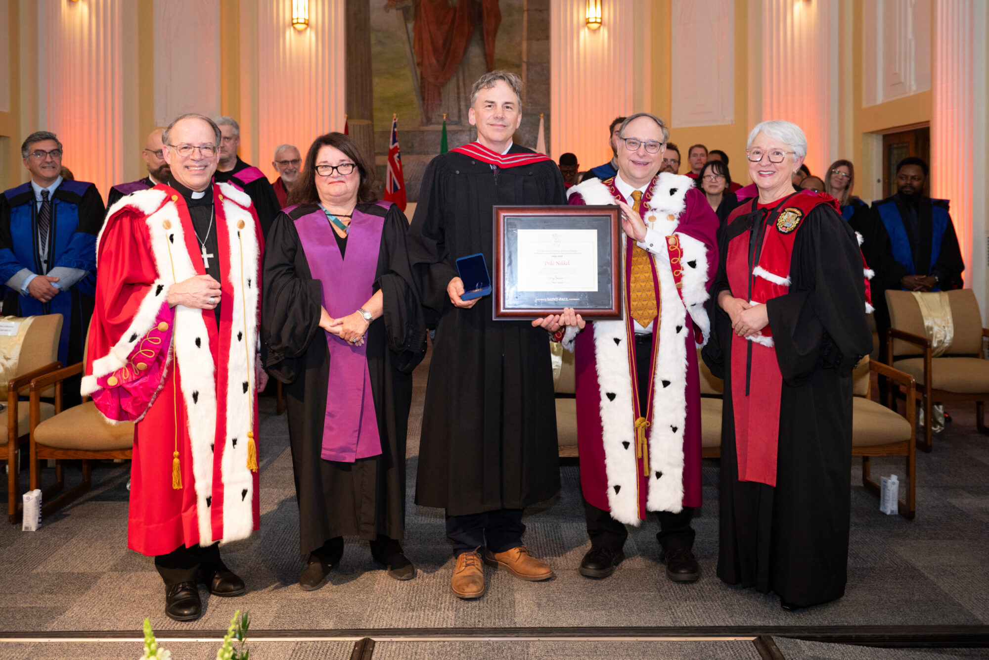 Dale Nikkel receives the Governor General's Academic Gold Medal alongside Saint Paul University officials.