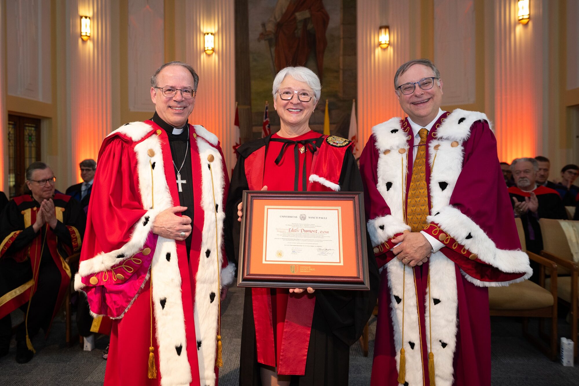 The Honourable Edith Dumont, Lieutenant Governor of Ontario, holds her honorary doctorate alongside Saint Paul University officials.