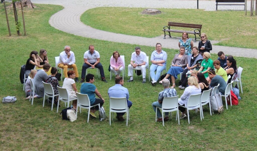 Cercle de personnes assises dans un champ / Circle of people seated in an open field