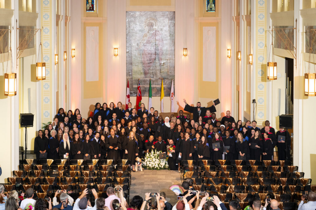 Graduates and faculty of the afternoon ceremony gather for a group photo in the De Mazenod Chapel.