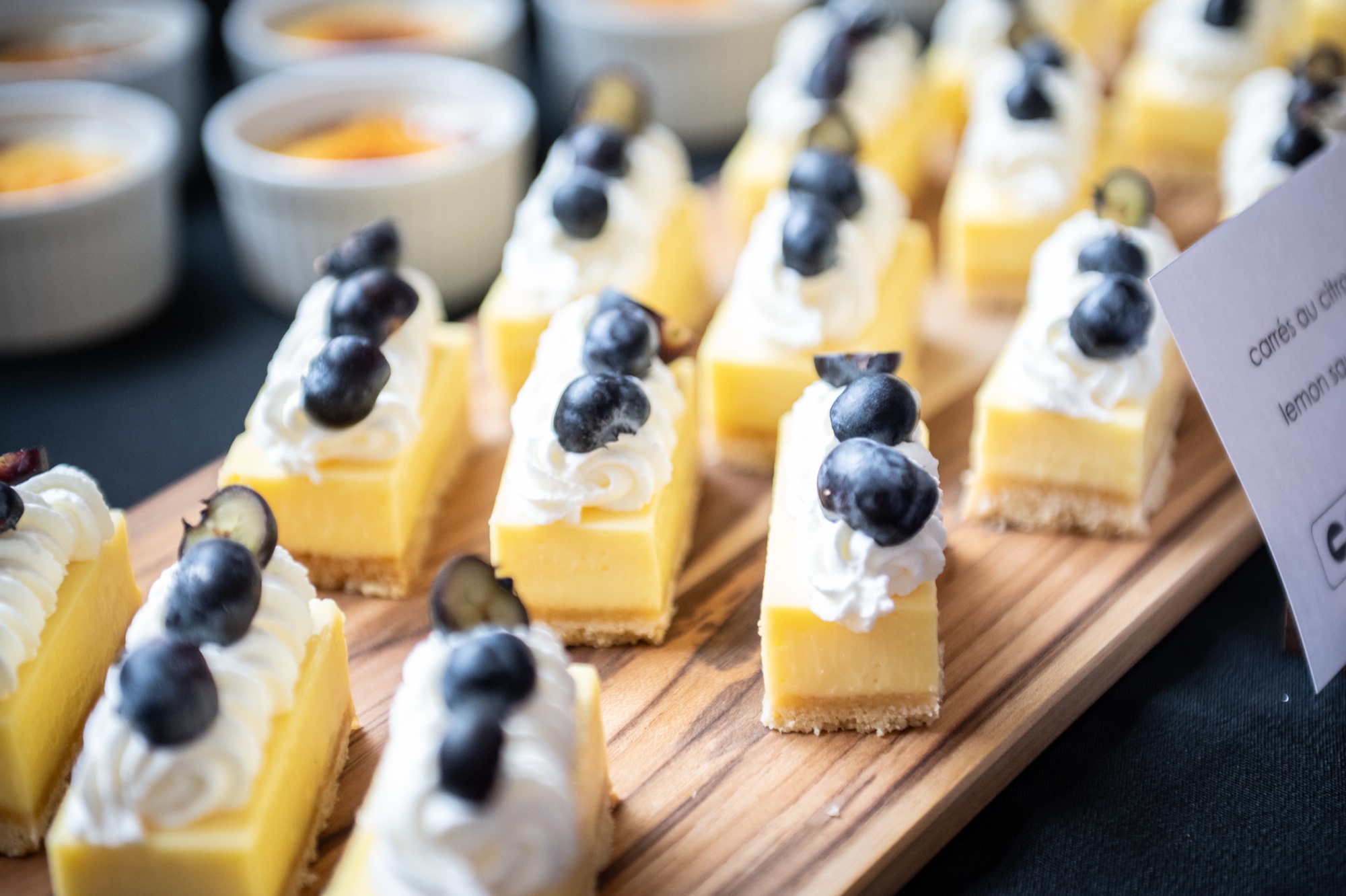 Lemon dessert squares topped with cream and blueberries