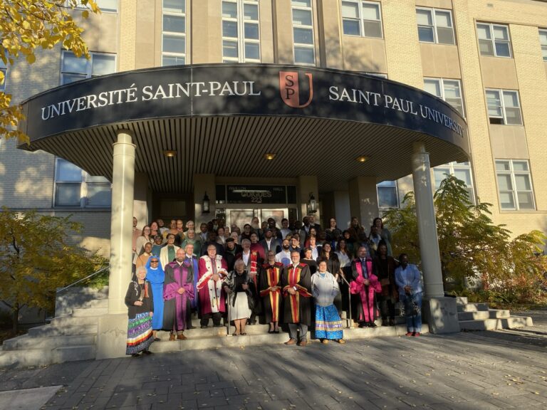 Un grand groupe d’invités, dont certains en toge, réuni sur les marches du pavillon Guigues de l’Université Saint-Paul pour le 10e anniversaire de l’École d’innovation sociale Élisabeth-Bruyère.